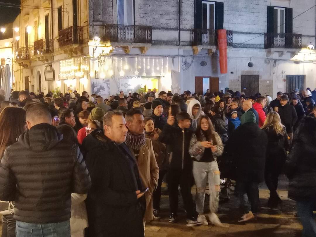 piazza_IV_Novembre_piena_di_gente_inverno_di_sera.jpg